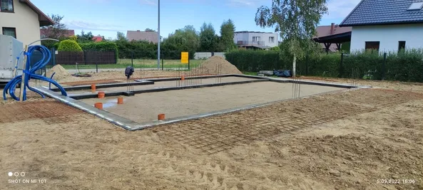 Przygotowanie płyty fundamentowej: obrzeże, zbrojenie i przejścia instalacji kanalizacyjnej